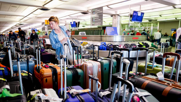 A traveler searches for a suitcase in a baggage holding area for Southwest Airlines at Denver International Airport on December 28, 2022.