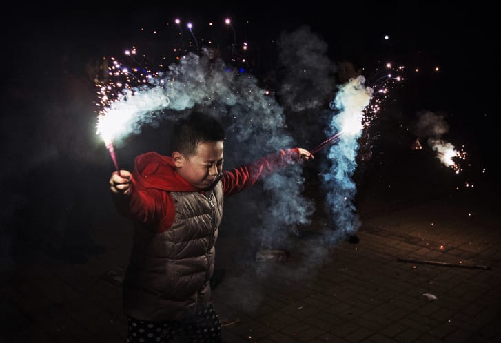 2005年，一个男孩用烟火庆祝北京的中国农历新年。 