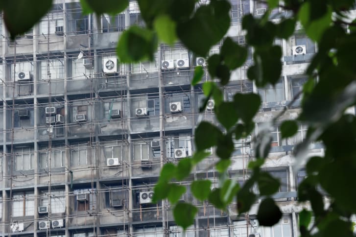 Air conditioning units line a side of a building in downtown New Delhi.