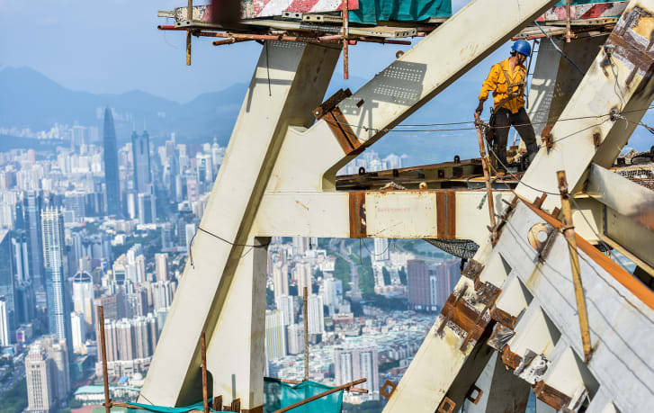 A worker braves the heat to weld parts on the top of Shenzhen's Ping An Finance Center in 2015.