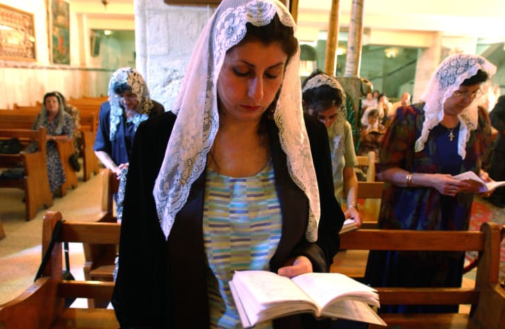 A Greek Orthodox Christian woman attends Friday mass service in the West Bank town of Ramallah, Palestine, wearing a lace veil.