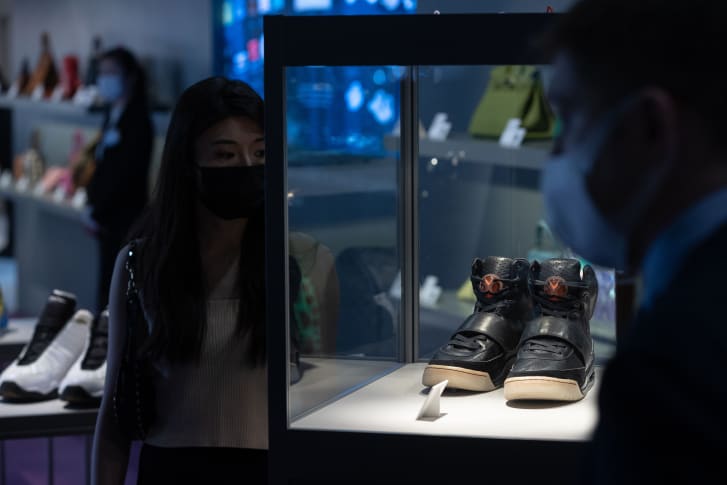 Visitors look at Kanye West 'Grammy Worn' Nike Air Yeezy 1 Prototype sneakers (R) on display during a Sotheby's auction preview in Hong Kong, China, 17 April 2021.