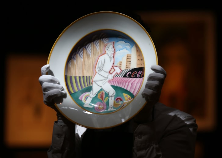 A Christie's technician holds a Soviet porcelain propaganda platter at the auction house's London showroom in 2018.