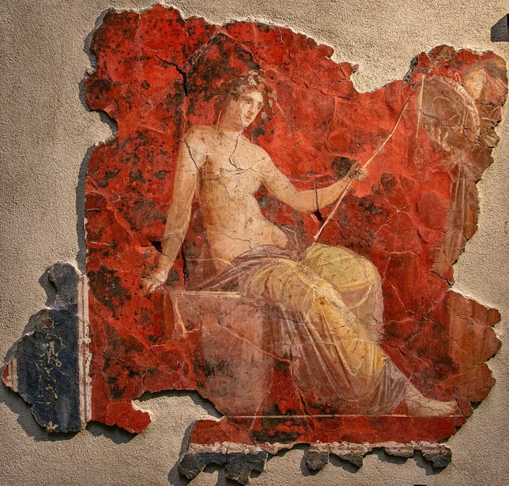 Dionisi, perëndia i verës, i njohur gjithashtu si Bacchus, i paraqitur në një sfond të kuq.