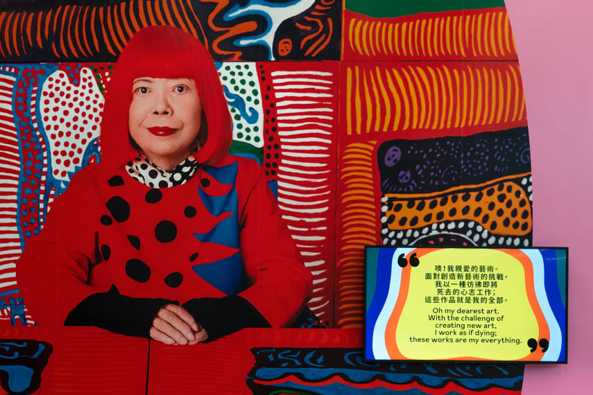 An image of Kusama wearing a signature red wig, featured in exhibition materials. 