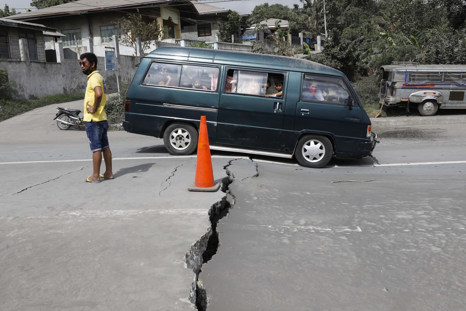 عائلة تحاول عبور طريق تضرر على إثر الزلزال الناتج عن البركان