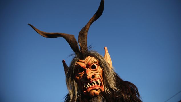 HAIMING, AUSTRIA - DECEMBER 01: A member of the Haiminger Krampusgruppe dressed as the Krampus creature arrives prior to the annual Krampus night in Tyrol on December 1, 2013 in Haiming, Austria. Krampus, in Tyrol also called Tuifl, is a demon-like creature represented by a fearsome, hand-carved wooden mask with animal horns, a suit made from sheep or goat skin and large cow bells attached to the waist that the wearer rings by running or shaking his hips up and down. Krampus has been a part of Central European, alpine folklore going back at least a millennium, and since the 17th-century Krampus traditionally accompanies St. Nicholas and angels on the evening of December 5 to visit households to reward children that have been good while reprimanding those who have not. However, in the last few decades Tyrol in particular has seen the founding of numerous village Krampus associations with up to 100 members each and who parade without St. Nicholas at Krampus events throughout November and early December. (Photo by Sean Gallup/Getty Images)
