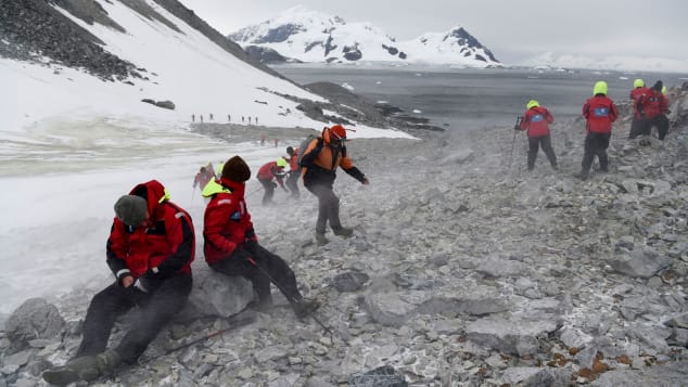 Tourists struggle to climb up a hill in Orne Harbour, Antarctic, on March 05, 2016